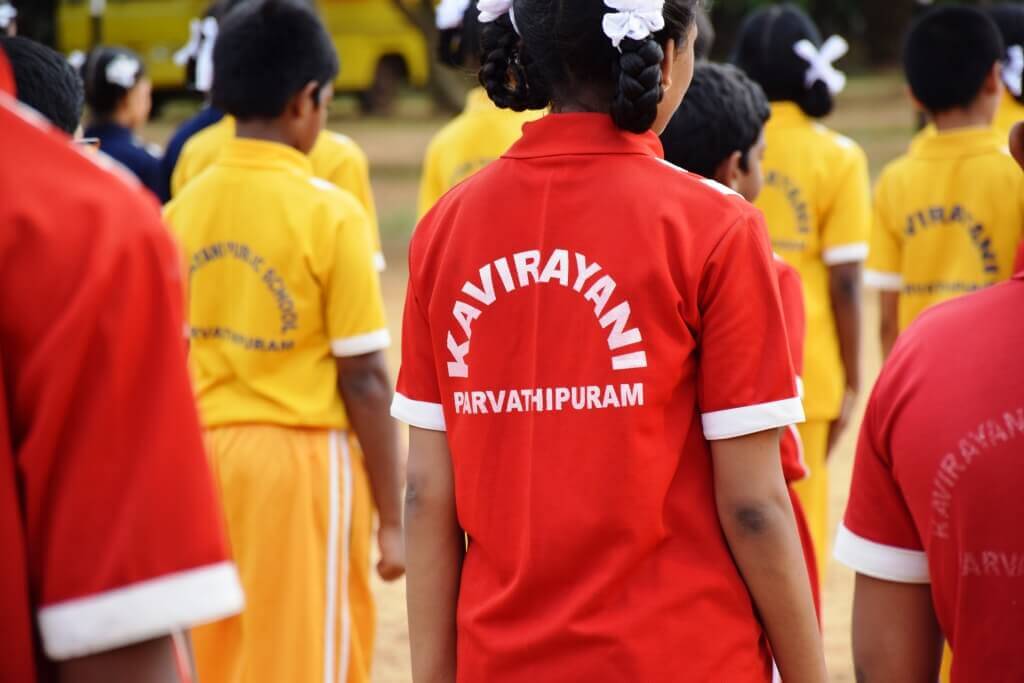 Students in red house uniforms on parade